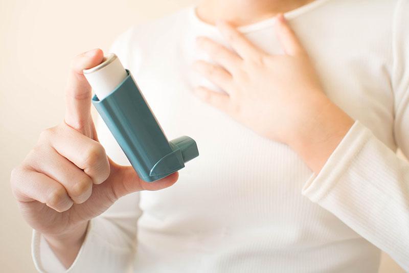 Mies käyttää astmapiippua