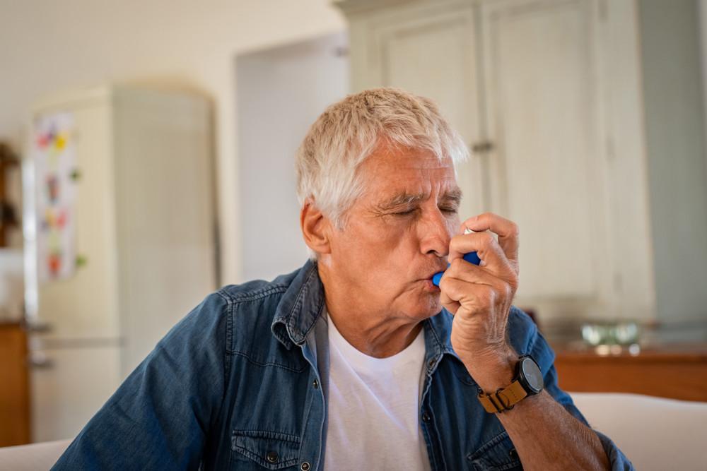 Mies käyttää astmapiippua