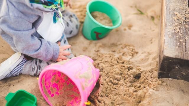 Lapsi leikkii hiekkalaatikossa ämpäreillä